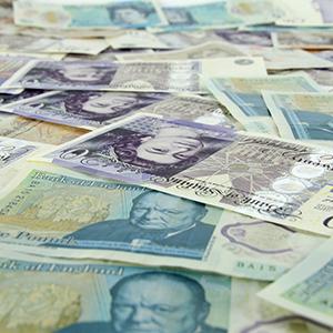 British paper money scattered over a surface by Christopher Bill on Unsplash.com